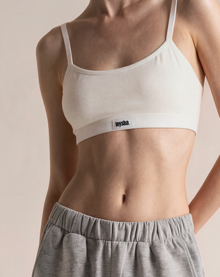 teysha organic cotton crop top bra in off-white, on model styled with grey track pants