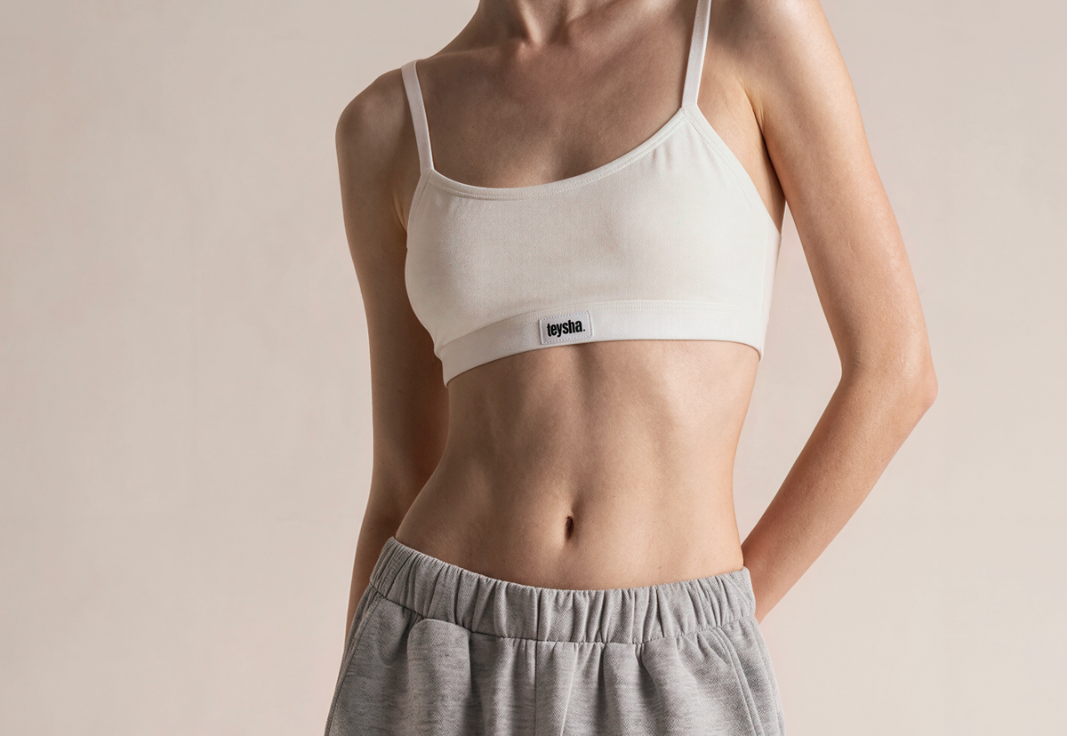 teysha organic cotton crop top bra in off-white, on model styled with grey track pants